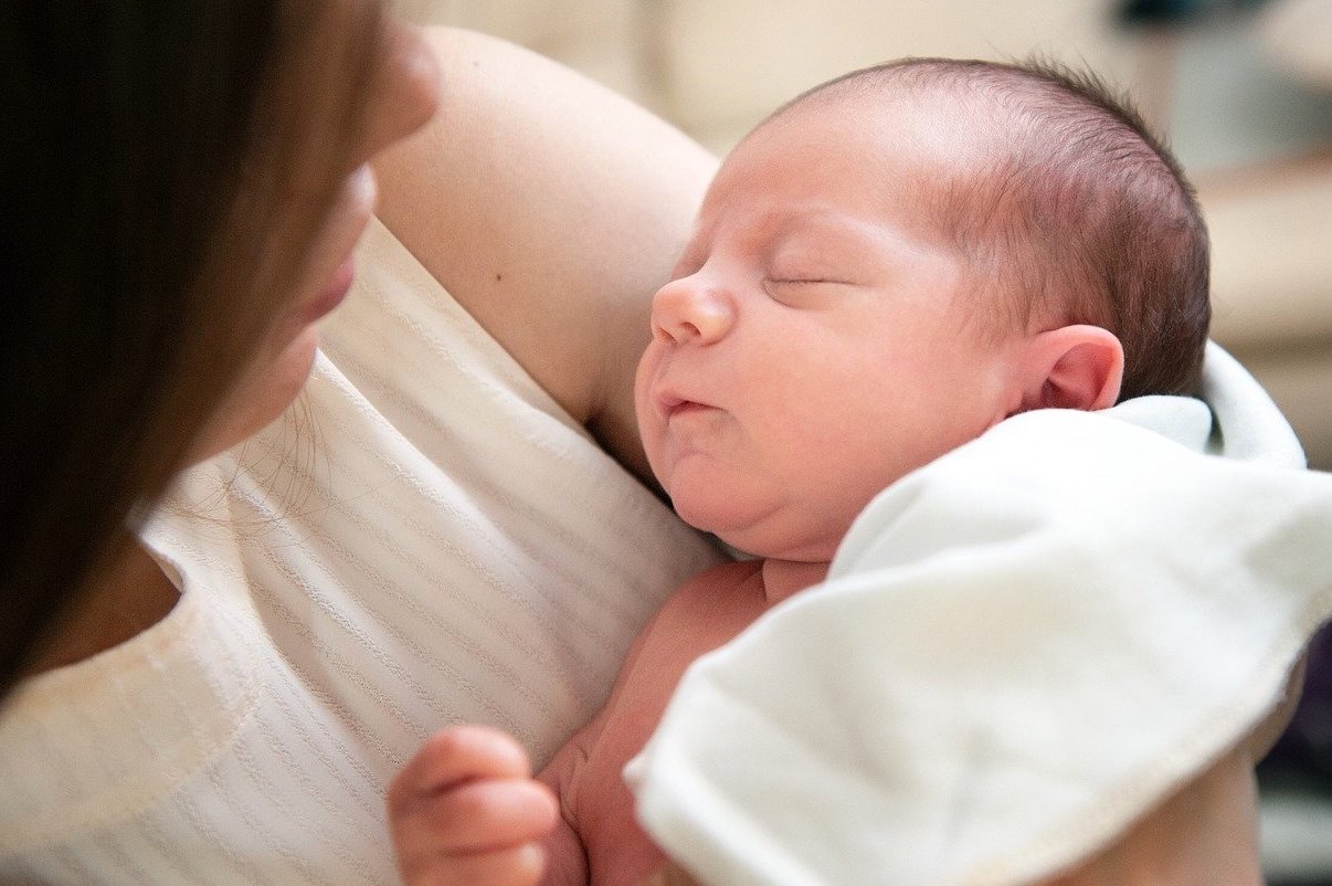 Une jeune maman qui présente sont enfant nouveau né
